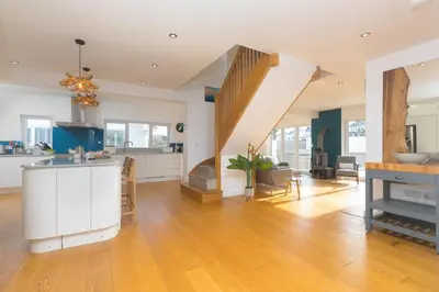 a kitchen and living room with a staircase at Solstice in Carbis Bay
