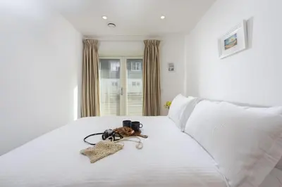 a bedroom with a white bed with cameras on it at Close to the Beach, Wi-Fi, Parking in Newquay