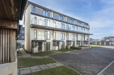 a large white building with windows on a street at Close to the Beach, Wi-Fi, Parking in Newquay