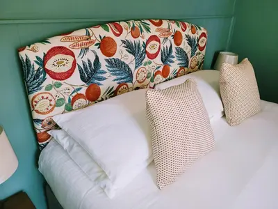a bed with two pillows and a headboard with fruit pattern at Jacobs Ladder Inn & Brewery in Falmouth