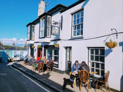 a group of people sitting outside of a building at Jacobs Ladder Inn & Brewery in Falmouth