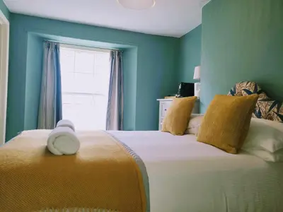 a bedroom with a large bed with a window at Jacobs Ladder Inn & Brewery in Falmouth