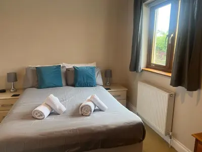 a bedroom with a bed with three pillows on it at Double room with WiFi! in Saint Columb Major