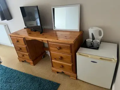 a wooden desk with a television on top of it at Double room with WiFi! in Saint Columb Major