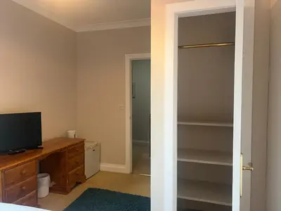 a bedroom with a tv and a closet at Double room with WiFi! in Saint Columb Major