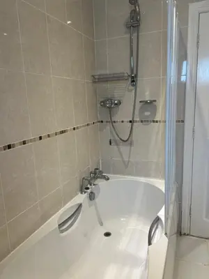 a bath tub with a shower in a bathroom at Double room with WiFi! in Saint Columb Major