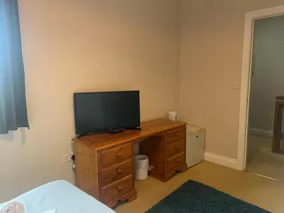a television on a wooden dresser in a bedroom at Double room with WiFi! in Saint Columb Major