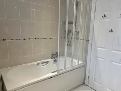 a white bath tub with a shower in a bathroom at Double room with WiFi! in Saint Columb Major