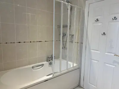 a bathroom with a bath tub with a shower at Double room with WiFi! in Saint Columb Major