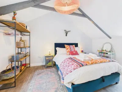 a bedroom with a bed and a book shelf at Cosy Cornish Cottage with Firepit & Parking in Newlyn East