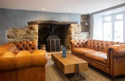 a living room with two brown leather couches and a table at Stunning Lodge with sea and country views, sleeps 6 in Newquay