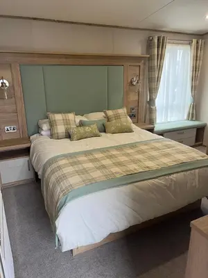 a bedroom with a large bed and a window at Stunning Lodge with sea and country views, sleeps 6 in Newquay