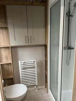 a bathroom with a toilet and a glass shower at Stunning Lodge with sea and country views, sleeps 6 in Newquay
