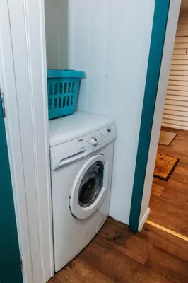 a washing machine with a basket on top of it at Heron's Perch- A pond-side retreat with cinema room in Callington