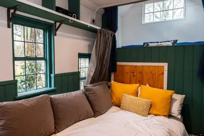 a living room with a couch with yellow pillows at Heron's Perch- A pond-side retreat with cinema room in Callington