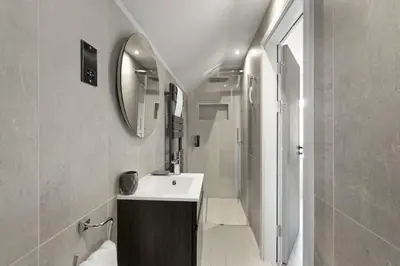 a bathroom with a sink and a shower with a mirror at Bright & Modern Townhouse Private Parking in Newquay
