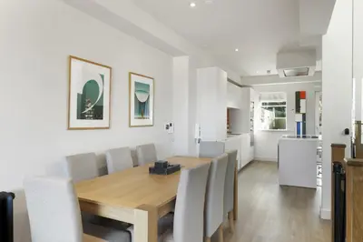 a dining room with a wooden table and chairs at Bright & Modern Townhouse Private Parking in Newquay