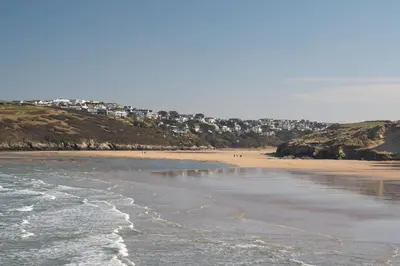 a sandy beach with buildings in the background at Bright & Modern Townhouse Private Parking in Newquay