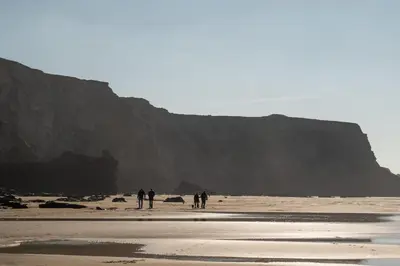 a group of people walking on the beach at Bright & Modern Townhouse Private Parking in Newquay