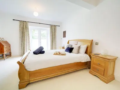 a bedroom with a large wooden bed and a window at Port View House in Bodmin