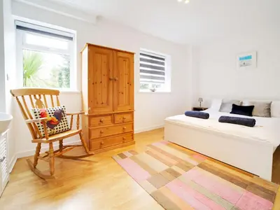 a bedroom with a bed and a chair and a window at Port View House in Bodmin