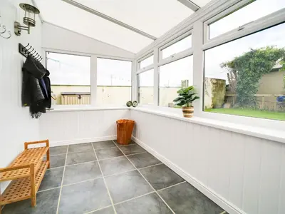 a conservatory with windows and a tiled floor at Port View House in Bodmin