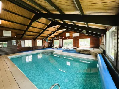 a large swimming pool in a building with at Malt-Barn Conversion, with access to Pool & Hot Tub-at Fox Valley Cottages in Lansallos