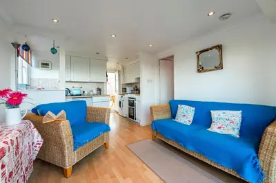 a living room with a blue couch and chairs at Clonmore Beach Chalet, Riviere Towans in Hayle