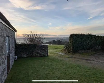 a house with a grass yard next to a building at Seaview Stable Barn in Penryn