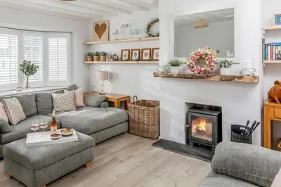a living room with a couch and a fireplace at Sandy Nook, Portreath, Cornwall in Portreath