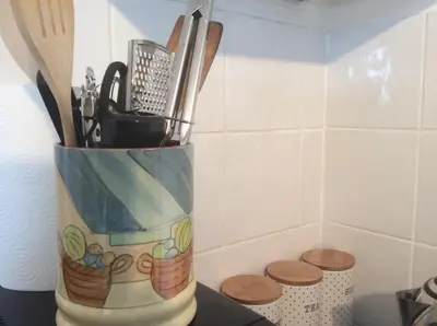 a container of kitchen utensils sitting on a counter at flat with Cornish charm, parking and garden in St Ives