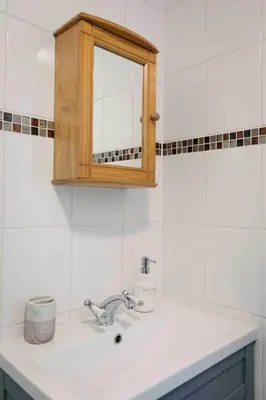 a bathroom sink with a medicine cabinet above it at flat with Cornish charm, parking and garden in St Ives