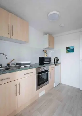 a kitchen with a sink and a stove top oven at flat with Cornish charm, parking and garden in St Ives
