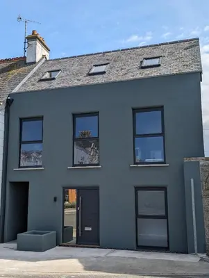 a white house with black doors and windows at Shorebreak Apartment 1 in Newquay