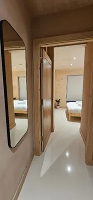 a bedroom with a mirror and two beds in it at Shorebreak Apartment 1 in Newquay