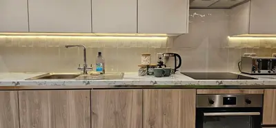 a kitchen with a sink and a counter top at Shorebreak Apartment 1 in Newquay