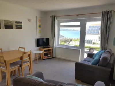a living room with a couch and a table and a dining room at Seaview Apartment in Phillack