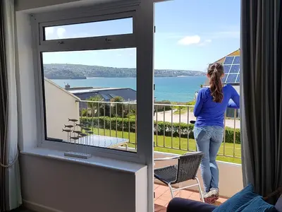 a woman standing on a balcony looking out at the ocean at Seaview Apartment in Phillack