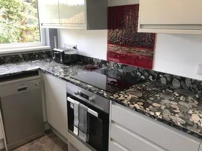 a kitchen with granite counter tops and a stove at Little Dusty - Between St Agnes & Perranporth in St. Agnes