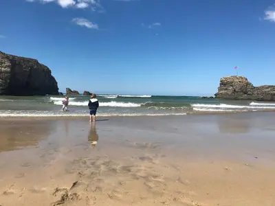 a person standing on a beach near the ocean at Little Dusty - Between St Agnes & Perranporth in St. Agnes