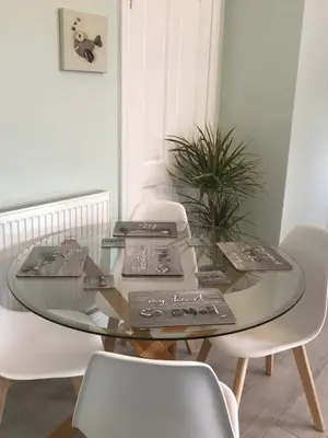 a glass dining room table with white chairs and a plant at Little Dusty - Between St Agnes & Perranporth in St. Agnes