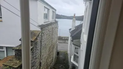 a view from a window of a street and a body of water at Potted Shrimp in Saint Mawes