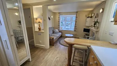 a kitchen and living room with a couch and a table at Potted Shrimp in Saint Mawes