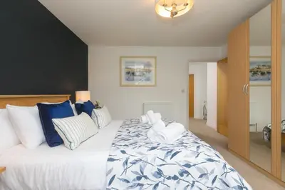 a bedroom with a large bed with blue and white pillows at Cockleshells in St Ives