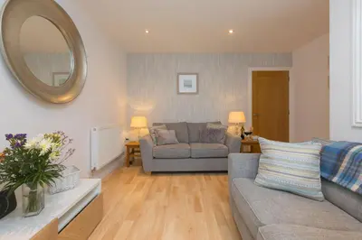 a living room with a couch and a mirror at Cockleshells in St Ives