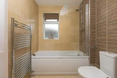 a bathroom with a bath tub and a toilet at Cockleshells in St Ives