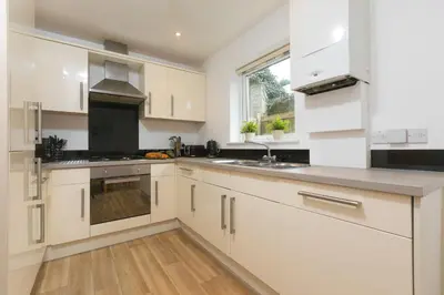 a kitchen with white cabinets and a sink at Cockleshells in St Ives