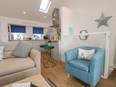 a living room with a couch and a chair at The Loft in Porthleven