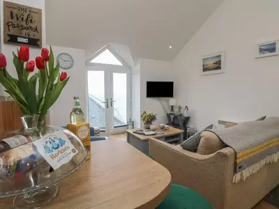 a living room with a table and a couch at The Loft in Porthleven