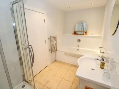 a bathroom with a shower and a sink at Penarvon House - Stunning Waterfront Escape with Games Room in Manaccan